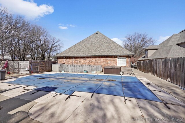 view of swimming pool featuring a hot tub and a patio