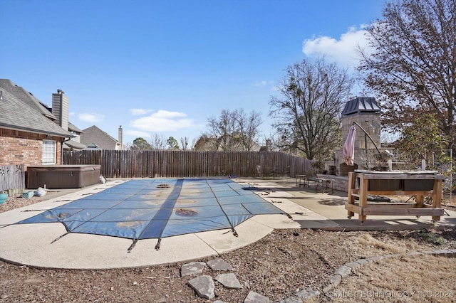 view of swimming pool with a patio area and a hot tub