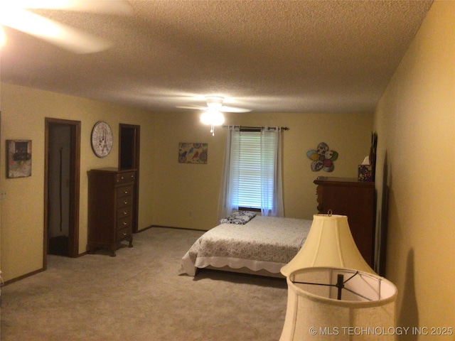 carpeted bedroom with ceiling fan and a textured ceiling