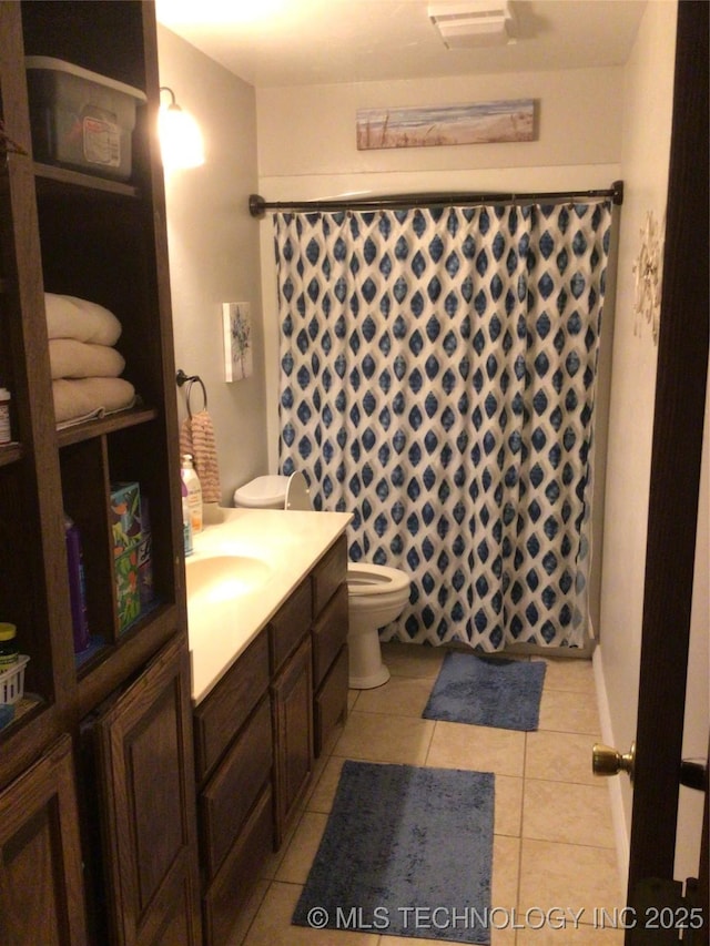 bathroom featuring vanity, tile patterned flooring, toilet, and walk in shower