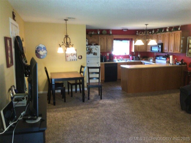 kitchen featuring dark carpet, decorative light fixtures, black appliances, and a center island