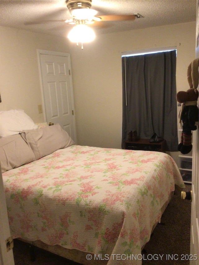 bedroom with ceiling fan and a textured ceiling