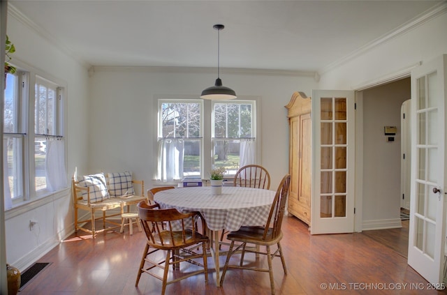 dining space with crown molding, plenty of natural light, dark hardwood / wood-style flooring, and french doors