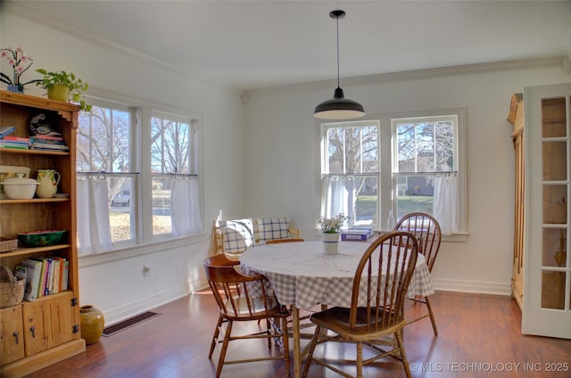 dining area with ornamental molding, dark hardwood / wood-style floors, and a wealth of natural light