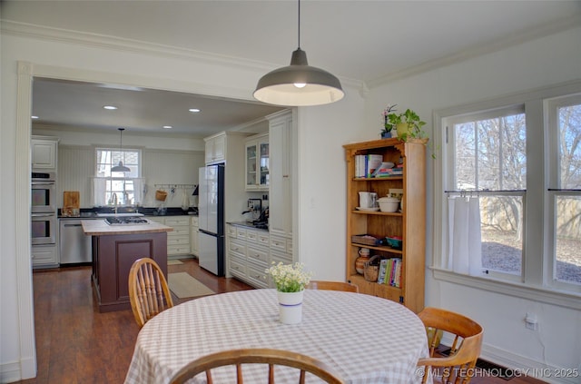 dining space featuring dark hardwood / wood-style flooring and crown molding