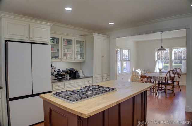 kitchen featuring white cabinetry, pendant lighting, wooden counters, and refrigerator