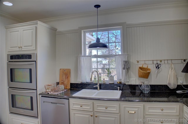 kitchen with white cabinetry, sink, stainless steel appliances, and dark stone counters