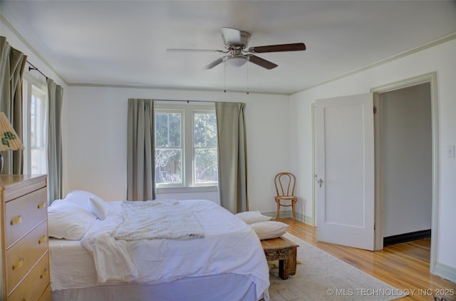 bedroom with crown molding, light hardwood / wood-style floors, and ceiling fan