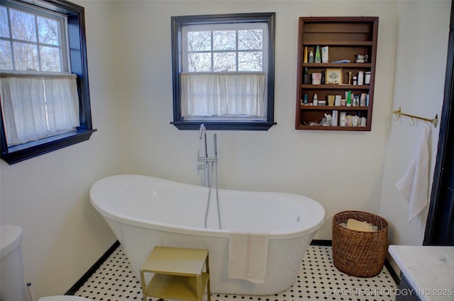 bathroom with a tub to relax in and plenty of natural light