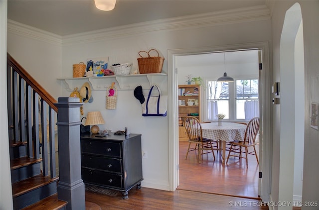 interior space with crown molding, dark hardwood / wood-style floors, and pendant lighting