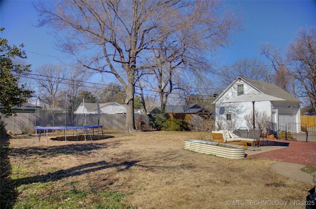 view of yard with an outdoor structure, a trampoline, and a patio area