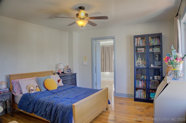 bedroom featuring crown molding, ceiling fan, and light hardwood / wood-style flooring