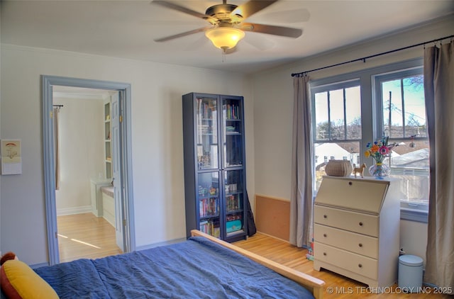 bedroom featuring connected bathroom, crown molding, and light wood-type flooring