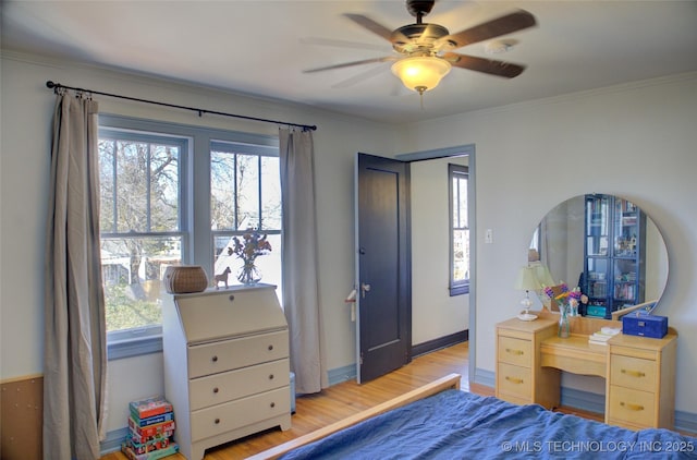 bedroom featuring hardwood / wood-style flooring, ceiling fan, crown molding, and multiple windows