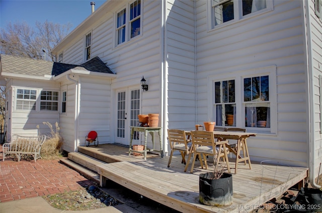 rear view of property featuring a wooden deck and a patio area