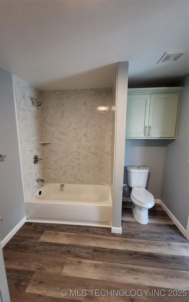 bathroom with tiled shower / bath, toilet, and hardwood / wood-style floors