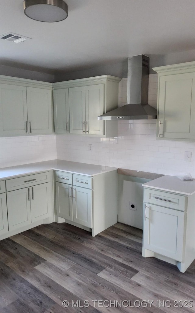 kitchen featuring white cabinetry, wall chimney range hood, and hardwood / wood-style flooring