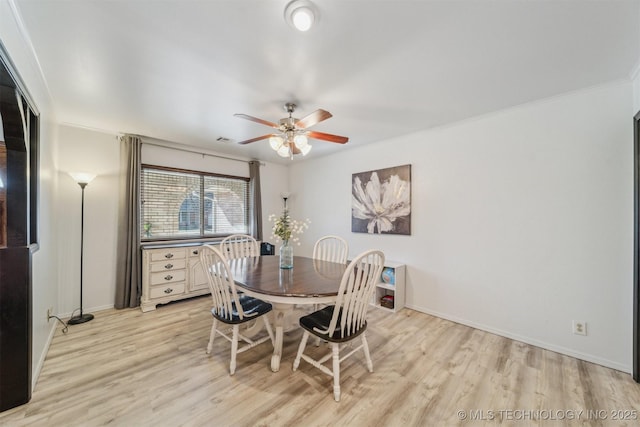 dining room with ceiling fan, ornamental molding, and light wood-type flooring