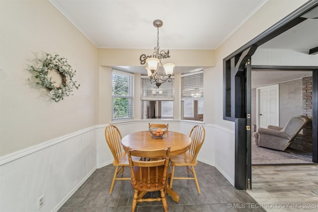 dining area featuring hardwood / wood-style flooring, ornamental molding, and a chandelier