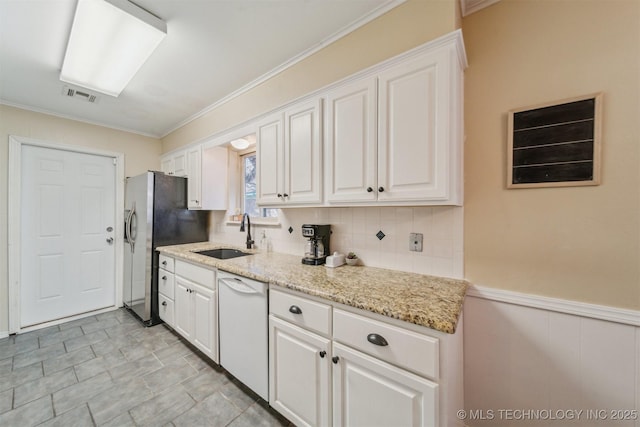 kitchen with sink, stainless steel fridge, dishwasher, white cabinetry, and light stone counters