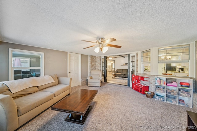 living room featuring ceiling fan, carpet floors, and a textured ceiling