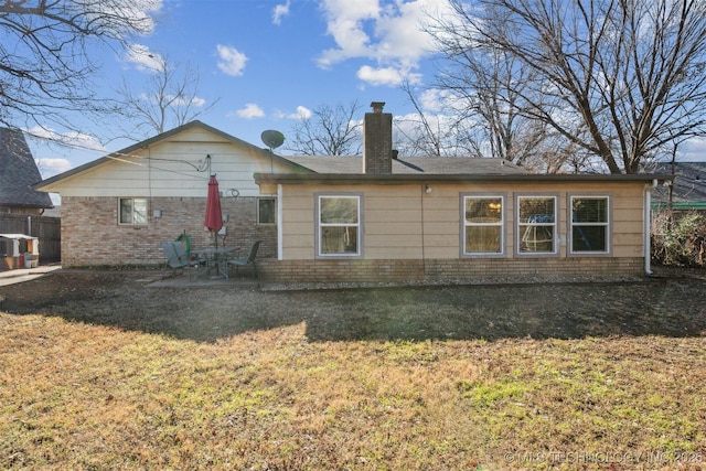 rear view of property featuring a patio and a yard