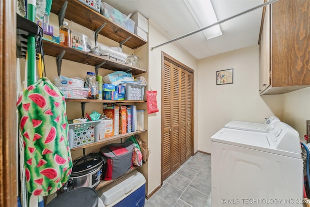 laundry room featuring cabinets, washer and dryer, and light tile patterned floors