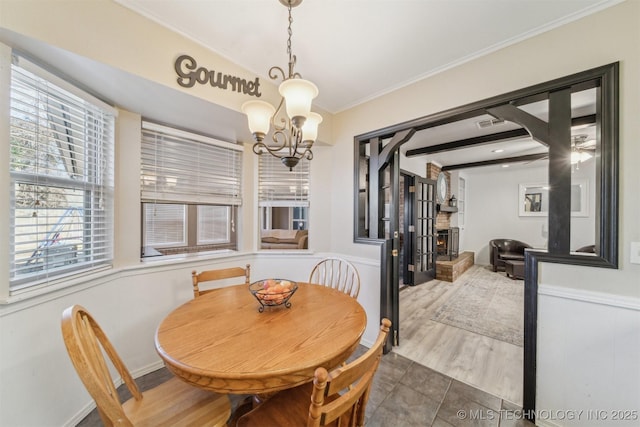 dining room with crown molding, beamed ceiling, hardwood / wood-style floors, and a notable chandelier