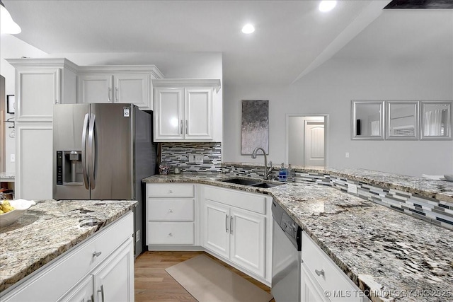 kitchen featuring appliances with stainless steel finishes, sink, white cabinets, and decorative backsplash