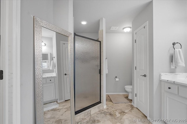 bathroom featuring a shower with door, vanity, and toilet