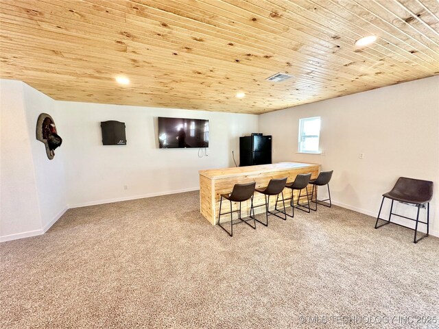 bar featuring black fridge, light carpet, and wooden ceiling