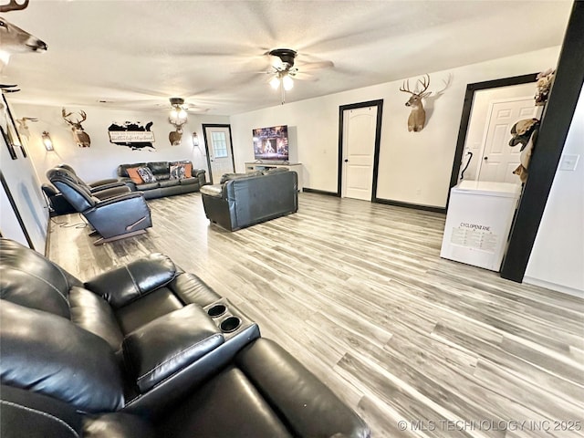 living room with ceiling fan and light hardwood / wood-style floors