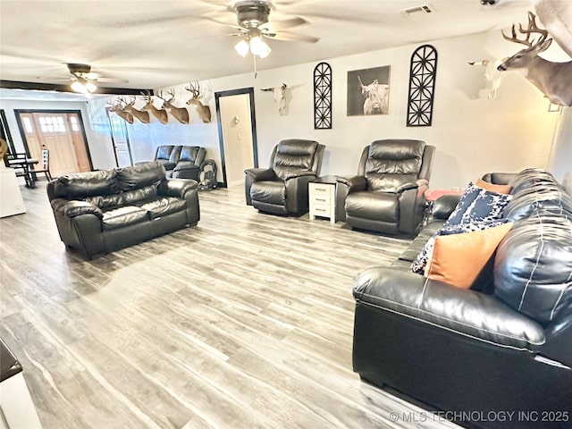 living room featuring light hardwood / wood-style flooring and ceiling fan