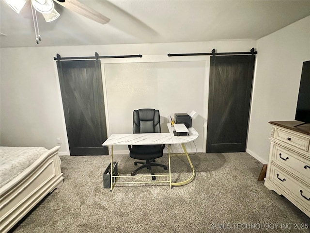 carpeted bedroom featuring ceiling fan and a barn door