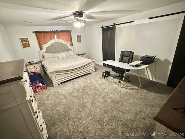 bedroom featuring a barn door, ceiling fan, and carpet