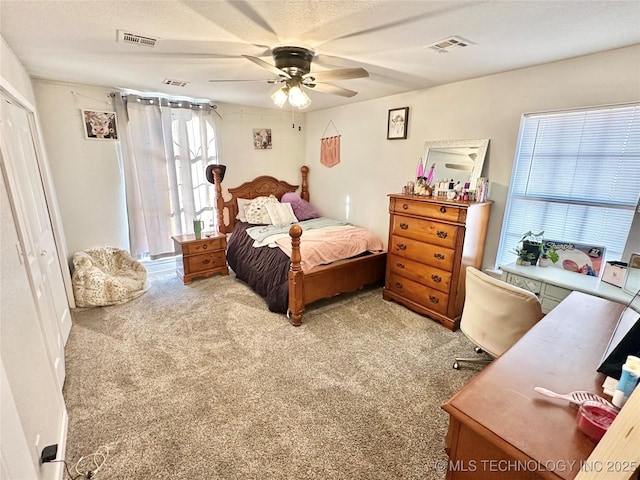 carpeted bedroom with ceiling fan and a textured ceiling