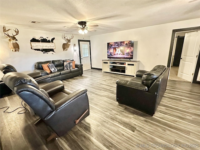 living room with ceiling fan, wood-type flooring, and a textured ceiling