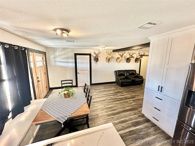 dining room with dark hardwood / wood-style flooring and a textured ceiling