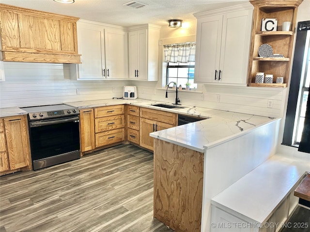 kitchen featuring white cabinetry, sink, kitchen peninsula, light stone countertops, and stainless steel electric range