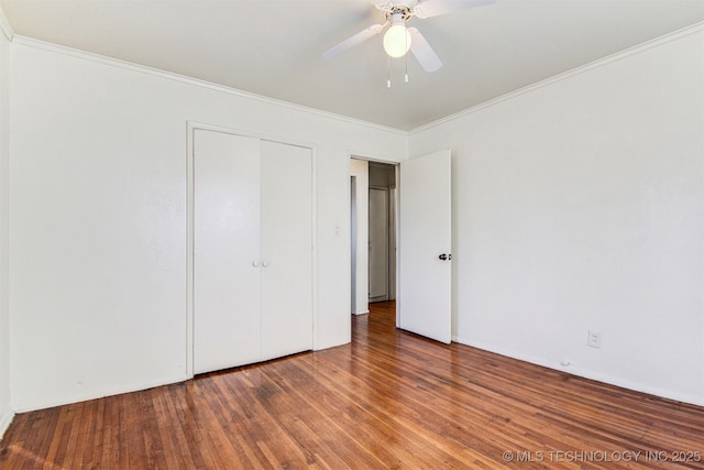 unfurnished bedroom featuring dark hardwood / wood-style flooring, crown molding, a closet, and ceiling fan