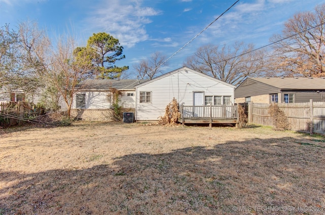 rear view of house featuring a deck and a lawn