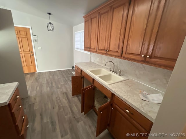 kitchen with hanging light fixtures, tasteful backsplash, sink, and dark hardwood / wood-style flooring