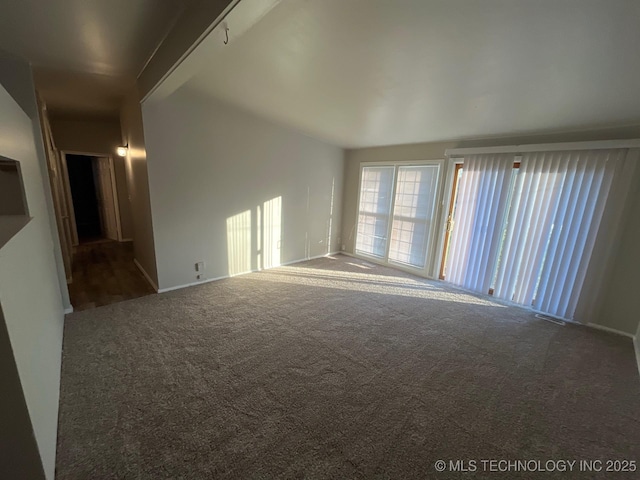 unfurnished living room with lofted ceiling and carpet