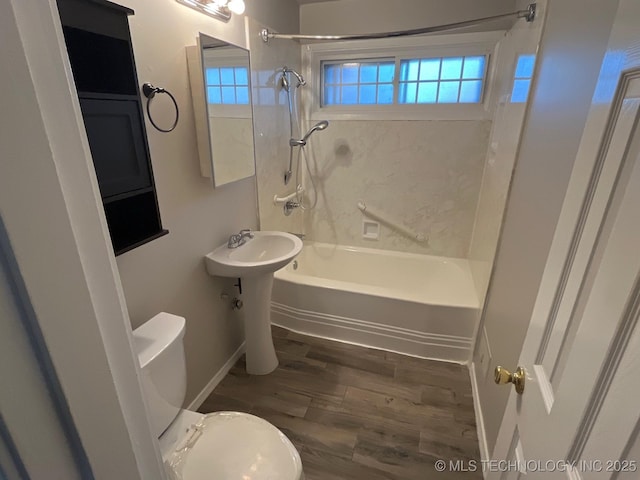 bathroom with tiled shower / bath, wood-type flooring, and toilet