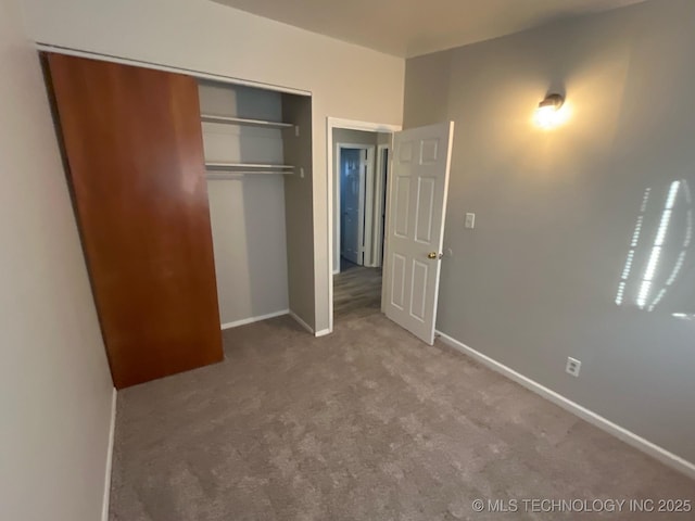 unfurnished bedroom featuring carpet floors and a closet