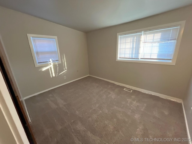 spare room with lofted ceiling and dark colored carpet