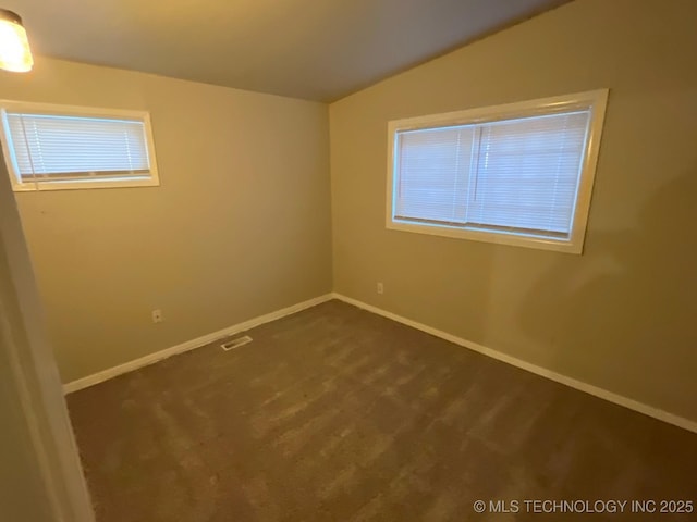 carpeted empty room with vaulted ceiling