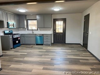 kitchen featuring stainless steel appliances, sink, and gray cabinetry