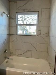 bathroom featuring tiled shower / bath