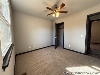 unfurnished bedroom with light colored carpet, a closet, and ceiling fan